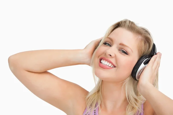 Mulher loira levantando os braços enquanto ouve música — Fotografia de Stock