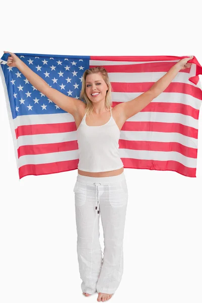 Fröhliche blonde Frau, die die amerikanische Flagge hisst — Stockfoto