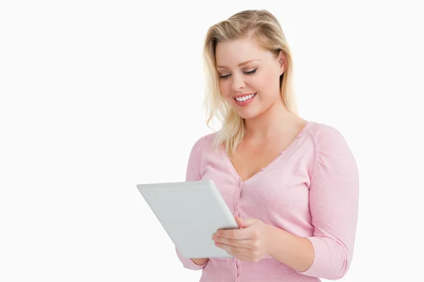 Blond kvinna stående medan du använder sin touchscreen — Stockfoto