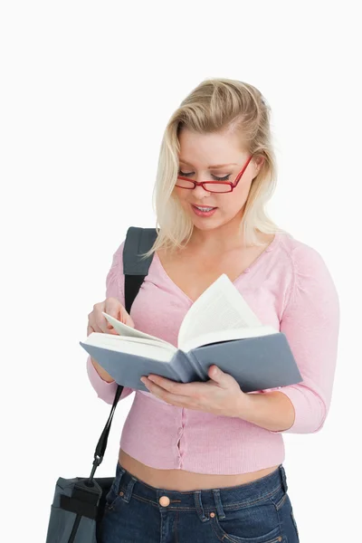 Serious woman reading a novel while wearing glasses — Stock Photo, Image