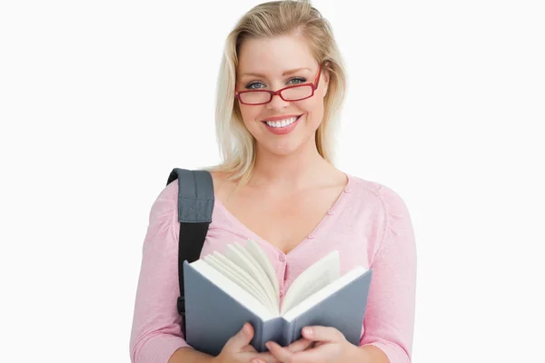 Happy woman holding a book while standing — Stock Photo, Image