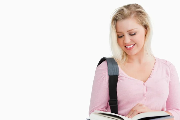 Lächelnde blonde Frau liest einen interessanten Roman — Stockfoto