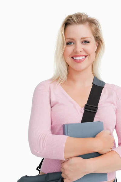 Mujer rubia mirando a la cámara mientras sostiene un libro — Foto de Stock