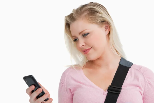 Mujer rubia de pie mientras envía un mensaje de texto — Foto de Stock