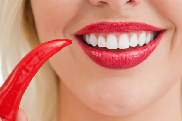 Sorrindo mulher loira segurando um chili — Fotografia de Stock