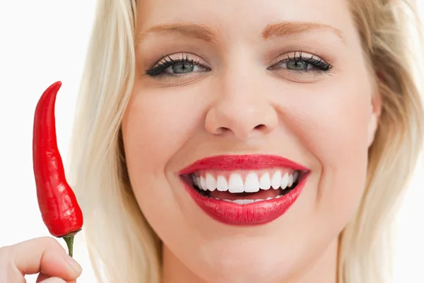 Glada blonda kvinnan visar en chili — Stockfoto