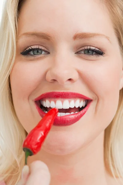 Mujer rubia feliz comiendo un chile — Foto de Stock