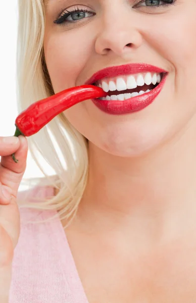 Mulher feliz comendo uma pimenta vermelha — Fotografia de Stock