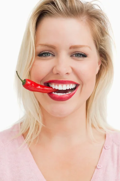 Szczęśliwy blond kobieta gryzienie chili — Zdjęcie stockowe