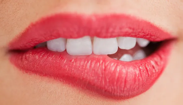 Vita tänder på en kvinna som bita hennes läppar — Stockfoto