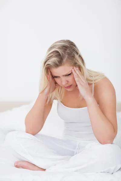 Blonde having a headache while sitting — Stock Photo, Image