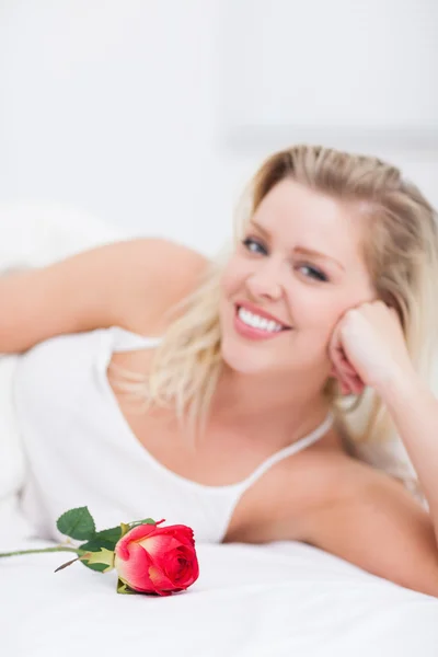 Jeune femme avec une rose souriante — Photo