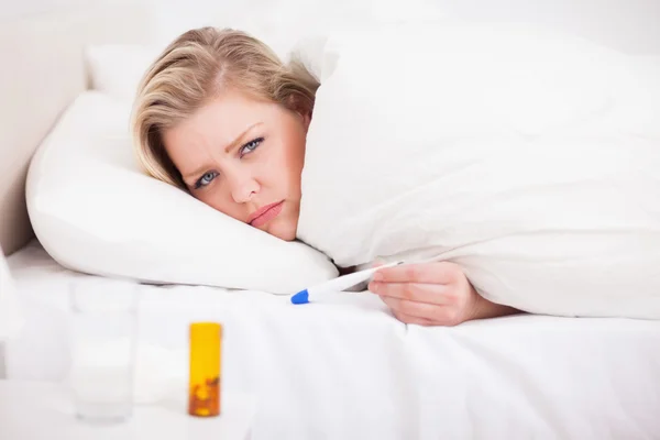 Mujer rubia enferma con un termómetro — Foto de Stock