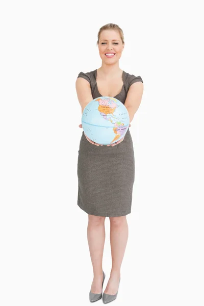Mulher sorrindo mostrando um globo — Fotografia de Stock