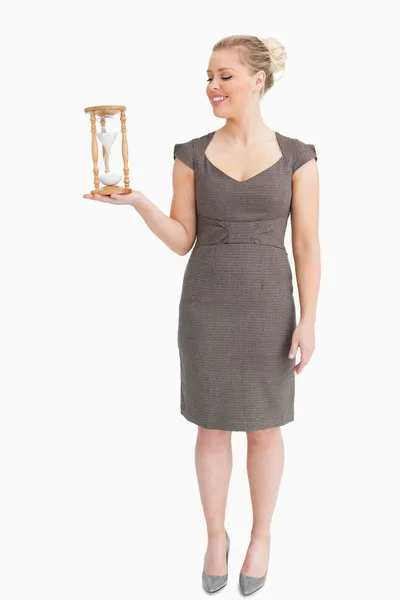 Mujer sosteniendo en su mano un reloj de arena — Foto de Stock