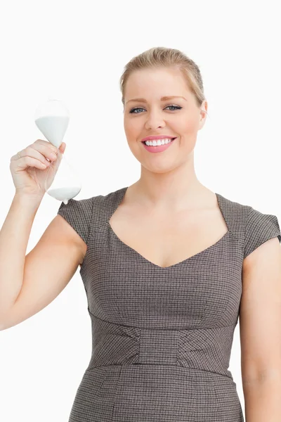 Woman smiling showing a hourglass in her hand — Stock Photo, Image