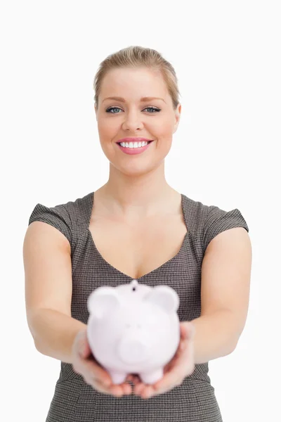 Piggy banco mostrando por uma mulher — Fotografia de Stock