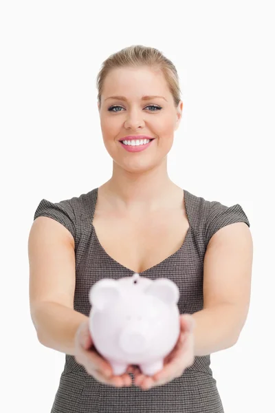 Piggy bank showing by a pretty woman — Stock Photo, Image