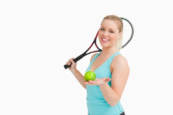 Vrouw die lacht terwijl een gele tennisbal wordt weergegeven — Stockfoto