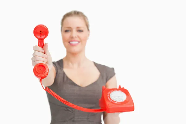 Mujer mostrando un teléfono retro rojo — Foto de Stock