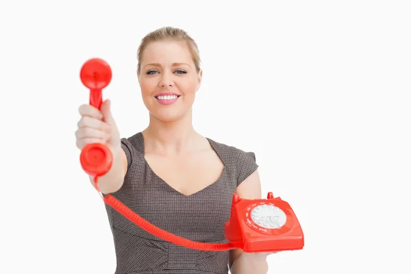 Sorrindo mulher mostrando um telefone retro — Fotografia de Stock