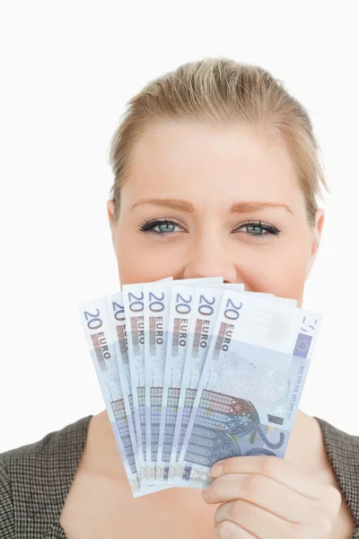 Woman hiding a middle of her face with euro banknotes — Stock Photo, Image