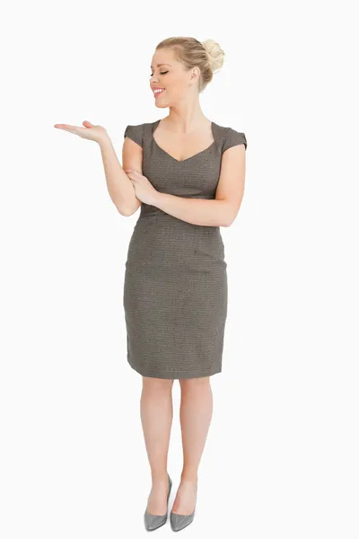 Vrouw op zoek naar haar hand presenteren iets — Stockfoto
