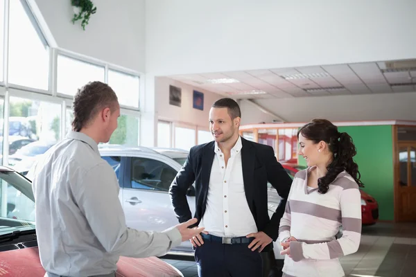 Coppia con un concessionario auto — Foto Stock