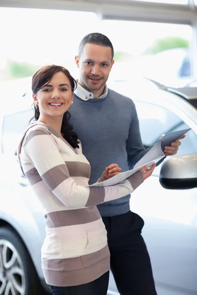 Smiling couple holding a document — Stock Photo, Image