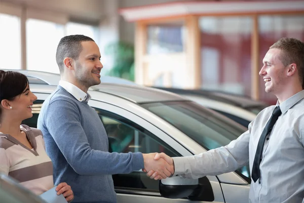 Vendedor sorrindo apertando a mão de um cliente — Fotografia de Stock