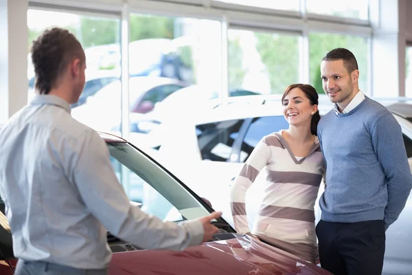 Smiling couple in a car shop — Stock Photo, Image