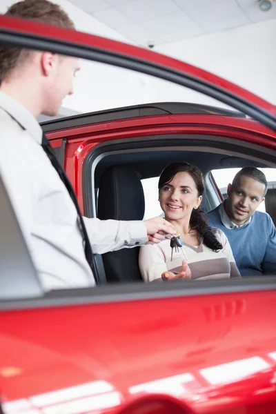 Uśmiechający się klient otrzymujący kluczyki do samochodu — Zdjęcie stockowe
