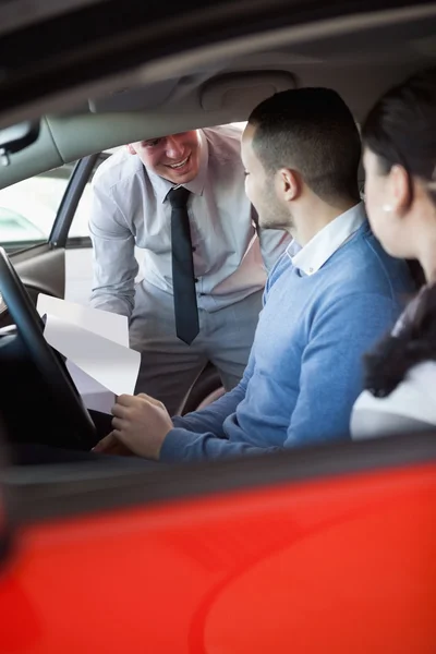 Vendeur donnant des clés de voiture à un couple dans une voiture — Photo