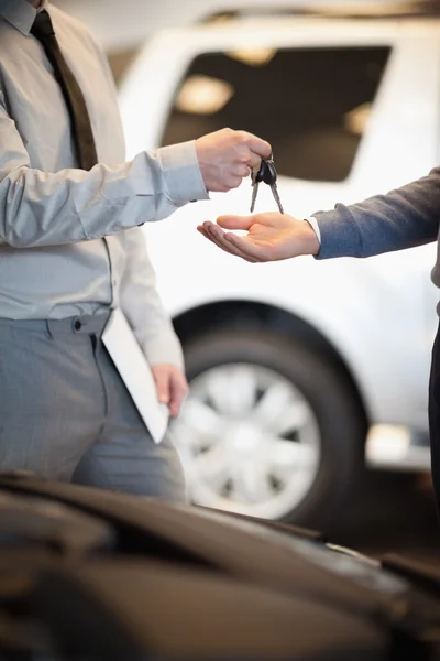 Salesman handing keys to a customer — Stock Photo, Image