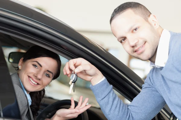 Mann übergibt Autoschlüssel an Frau — Stockfoto