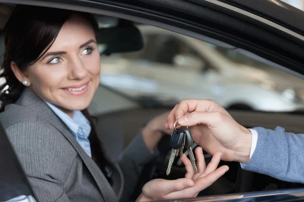 Mujer sonriente recibiendo llaves de un hombre — Foto de Stock