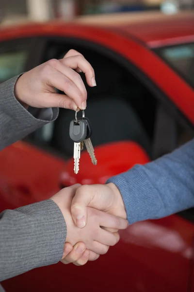 Shaking hands while holding keys — Stock Photo, Image