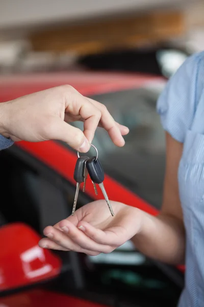 Bilnycklarna hålla av någon över någon annan hand — Stockfoto