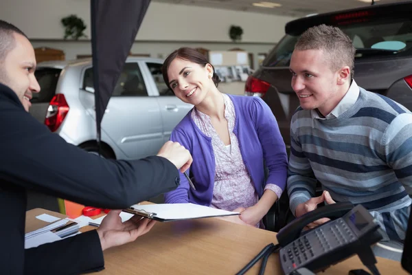 Paar chatten met een autoverkoper — Stockfoto