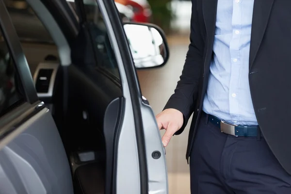 Hombre sosteniendo una puerta abierta — Foto de Stock