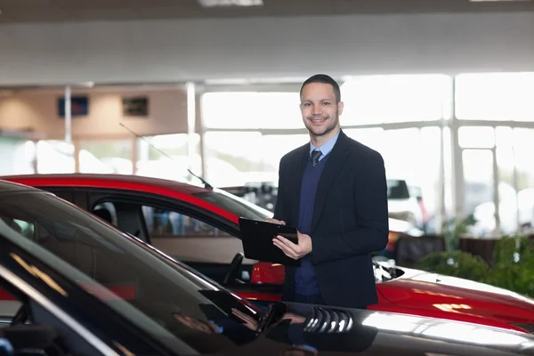 Man writing on a notepad beside a car — Stock Photo, Image