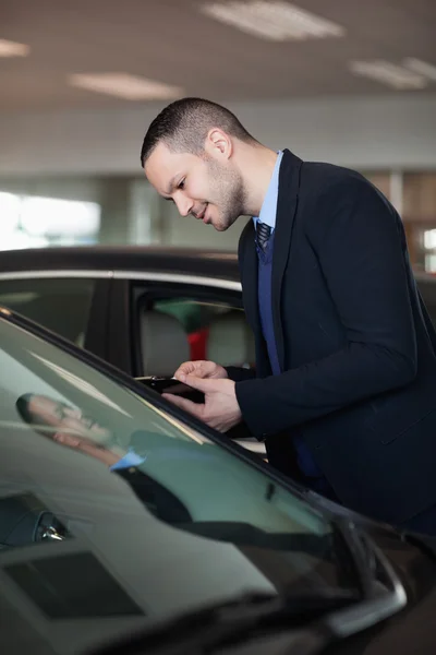 Salesman looking inside the car — Stock Photo, Image