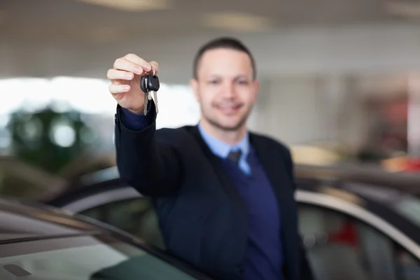 Negociante de pé enquanto segurando chaves do carro — Fotografia de Stock
