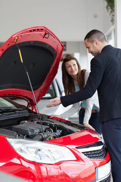 Arabanın motoru gösterilen satıcı — Stok fotoğraf