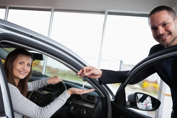 Femme assise dans sa voiture tout en tendant la main — Photo