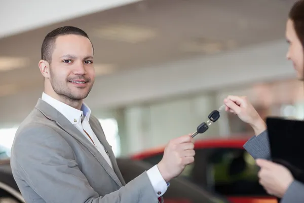 Homem segurando chaves do carro com uma mulher de negócios — Fotografia de Stock