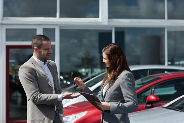 Businesswoman giving car keys to a client — Stock Photo, Image