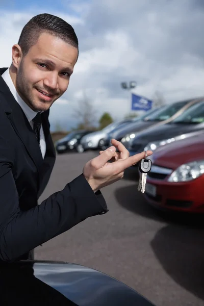 Man met autosleutels met een vinger — Stockfoto