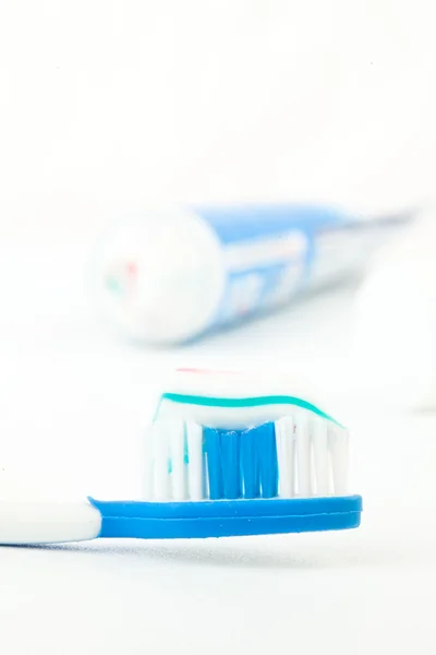 Tooth brush next to a tube of toothpaste — Stock Photo, Image