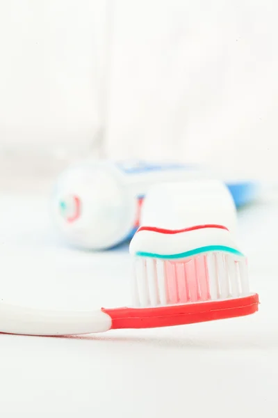 Tubo de pasta de dientes junto a un cepillo de dientes —  Fotos de Stock